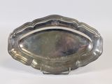a silver tray with a silver handle on a white surface