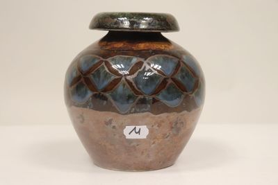 a brown and blue vase sitting on a white table