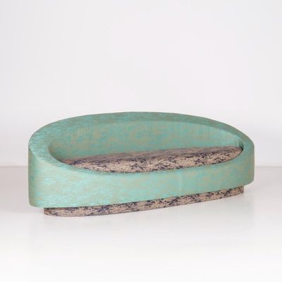 un petit bol vert bordé de marron, posé sur une table blanche