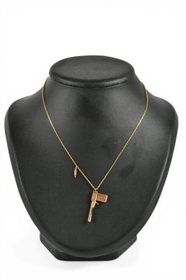 SWAROVSKI. Collier pendentif en métal doré "Bond Golden Gun"…