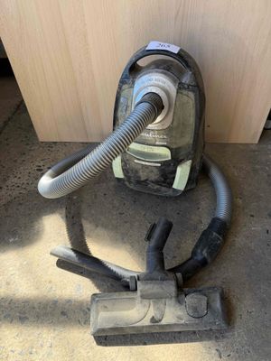 a vacuum that is sitting on the floor next to a piece of wood