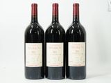 trois bouteilles de vin rouge sont alignées sur une surface blanche