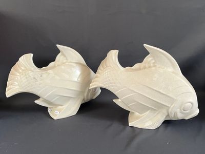 deux figurines de poissons en céramique blanche posées sur une table