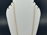 the gold chain necklace is shown on a white mannequin