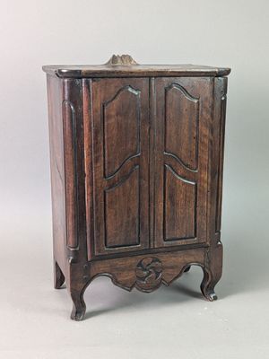 un petit meuble en bois surmonté d'une porte