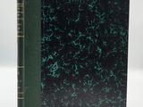 a book with a green cover and black pages on a white surface
