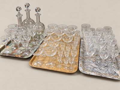 trois plateaux de verres et une carafe posés sur une table
