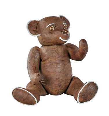 a brown teddy bear that is sitting on the ground