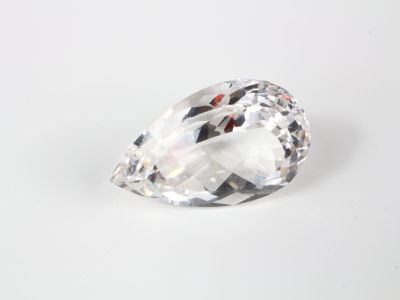 un gros plan d'un diamant transparent sur une surface blanche