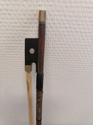 un bâton en bois et un support à bâton en bois posés sur une surface blanche