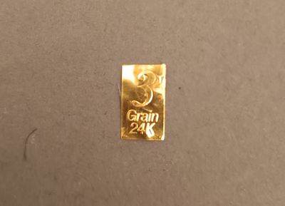 un gros plan d'une pièce d'or posée sur une surface marron