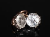 un gros plan sur une paire de boucles d'oreilles en diamant posées sur une surface noire