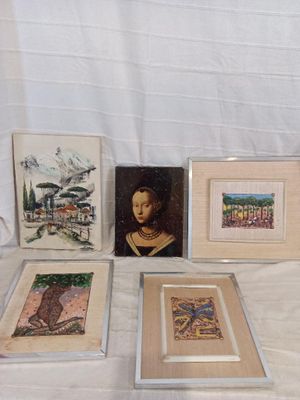 four framed pictures on a table with a white cloth