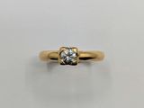 a yellow gold ring with a single diamond in the center