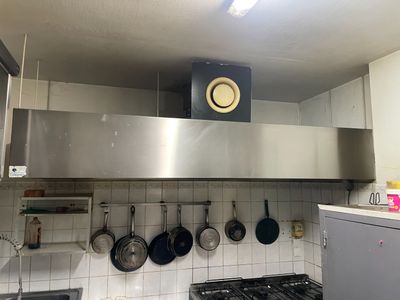 une cuisine où des casseroles et des poêles sont suspendues au plafond