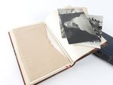 an open book sitting on top of a white table next to a stack of books