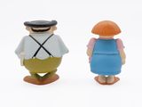 two figurines of a man and a woman standing next to each other