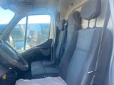 a white van with a black seat and a black bag in the back