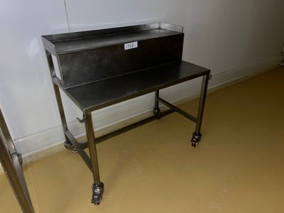 une photo d'une table de travail en acier inoxydable dans une pièce
