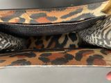 someone is holding a leopard print purse in their hand