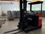 a forklift in the middle of a warehouse with pallets in the background