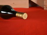 a bottle of wine sitting on a red table cloth