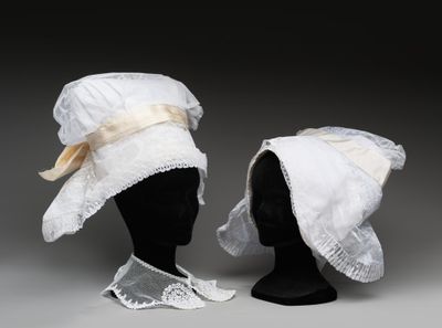 deux chapeaux blancs posés sur la tête d'un mannequin, sur fond gris