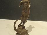 bronze statue of a woman with a snake on a pedestal