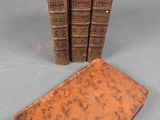 three old books sitting on top of a table next to each other