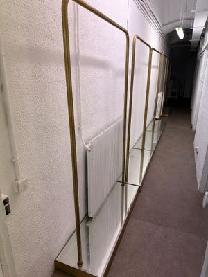 trois étagères en verre fixées au mur à côté d'un radiateur