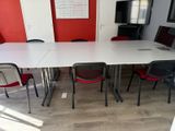 a white table and red chairs in a room