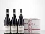 three bottles of red wine sit in front of a box