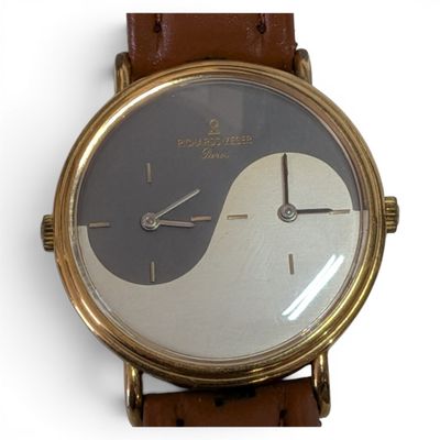 a watch that is sitting on a brown leather strap