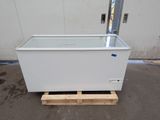 a white chest freezer sitting on a pallet in front of a building
