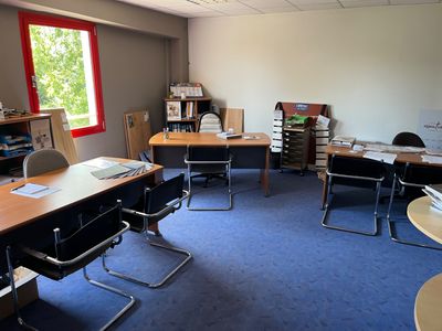 une image représentant une salle de classe avec des pupitres, des chaises et des étagères