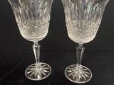 une paire de verres à pied en cristal posés sur une surface noire