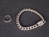 un bracelet en argent et une bague sur un fond noir