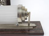 a silver object on a wooden stand with a white background