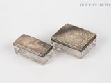 une paire de boîtes anciennes en métal argenté sur fond blanc