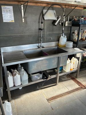a kitchen with a sink and a lot of bottles on the counter