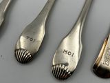 four spoons and a fork are lined up on a table