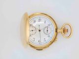 a gold pocket watch on a white surface