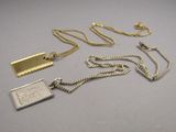 a silver necklace with a gold chain and a silver pendant with a coin on it