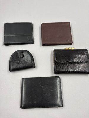 quatre modèles différents de portefeuilles en cuir posés sur un fond blanc
