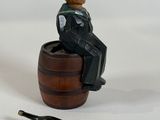 a figurine of a man sitting on a barrel with a bottle opener