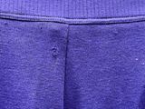 le bas d'un pantalon de survêtement violet orné d'un logo blanc