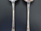 two spoons that are sitting next to each other on a table