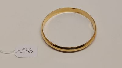 gros plan d'une bague en or sur une surface blanche