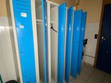 Plusieurs casiers bleus sont alignés les uns à côté des autres dans des toilettes publiques