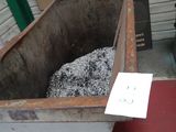 un grand conteneur métallique rempli de charbon, situé à côté d'un bâtiment